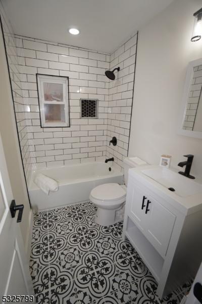 full bathroom featuring tile patterned floors, toilet, vanity, and tiled shower / bath