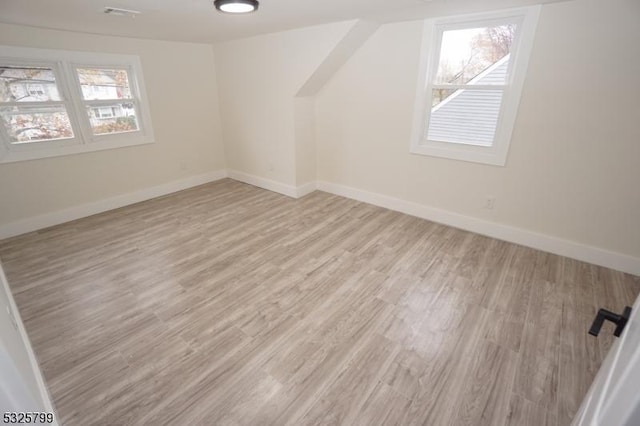 additional living space with light hardwood / wood-style flooring