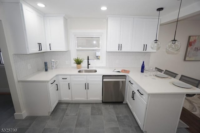 kitchen featuring kitchen peninsula, a kitchen breakfast bar, sink, decorative light fixtures, and dishwasher