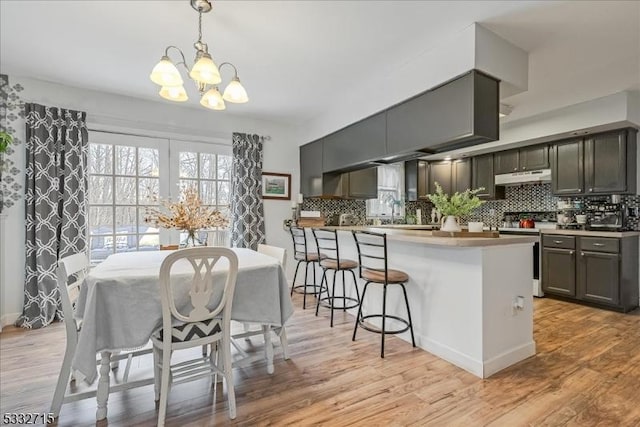 dining space featuring a notable chandelier and light wood-type flooring