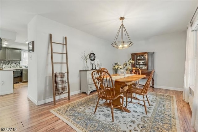 dining space with a notable chandelier and light hardwood / wood-style flooring