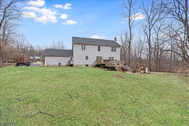 back of property with a lawn and a wooden deck