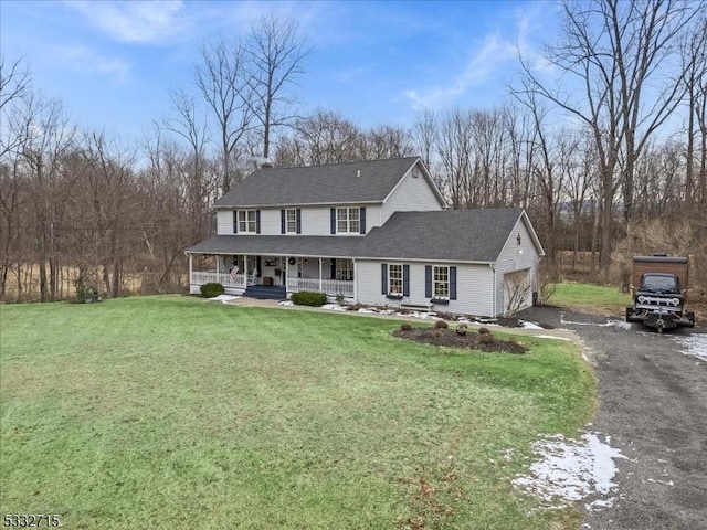 view of front of house featuring a front yard, covered porch, and a garage