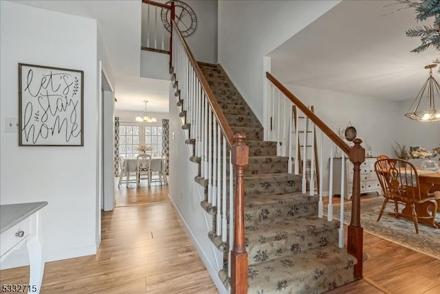 staircase featuring a chandelier and hardwood / wood-style flooring