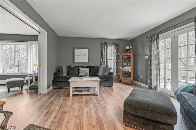 living room with french doors and light hardwood / wood-style flooring