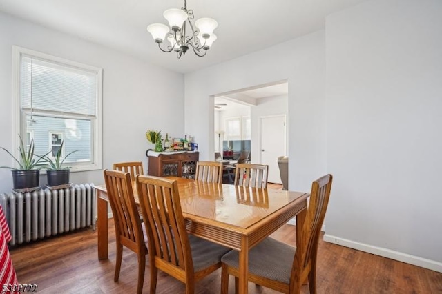 dining space with dark wood-type flooring, radiator heating unit, and a chandelier