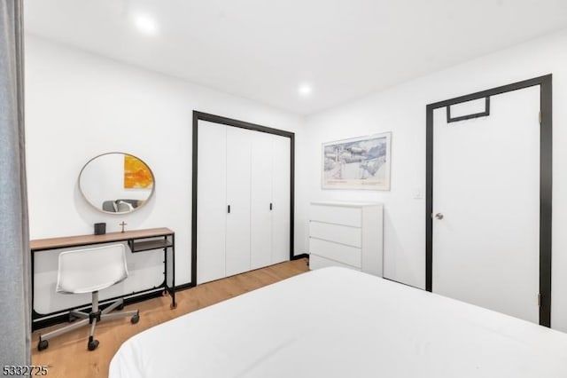 bedroom with light hardwood / wood-style flooring and a closet