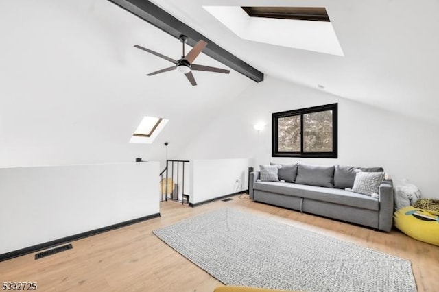 interior space featuring ceiling fan, light hardwood / wood-style floors, and vaulted ceiling with skylight