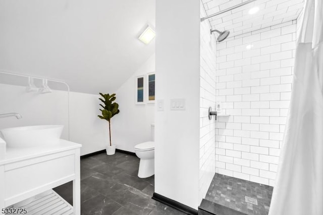 bathroom featuring sink, toilet, lofted ceiling, and a shower with curtain