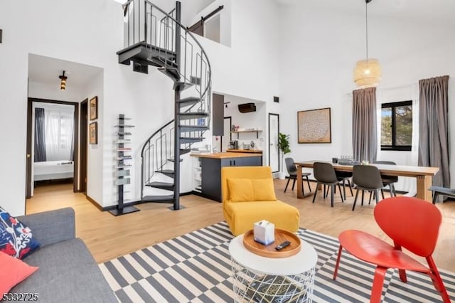 living room featuring a high ceiling and light hardwood / wood-style flooring