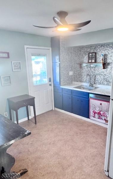 kitchen with sink, blue cabinetry, and backsplash