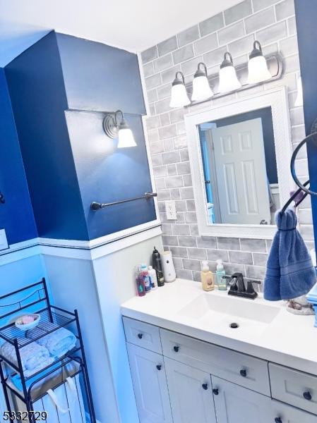 bathroom featuring vanity and tasteful backsplash