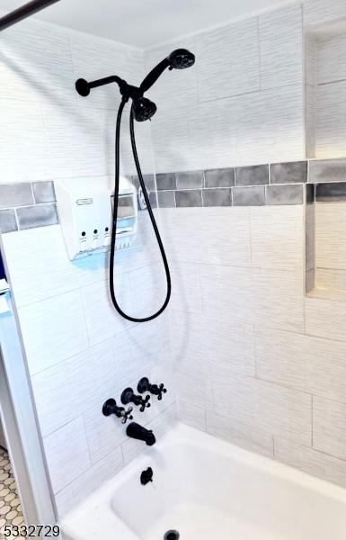 bathroom with tiled shower / bath combo