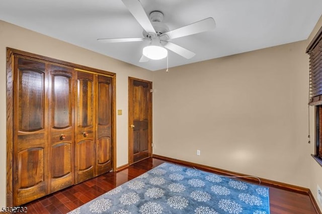 bedroom with a closet, dark hardwood / wood-style floors, and ceiling fan