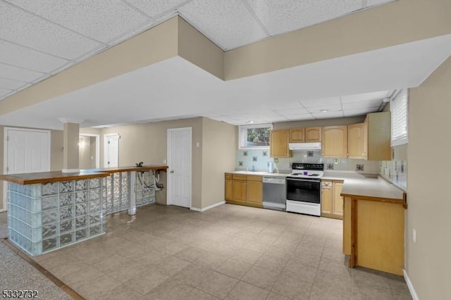 kitchen with a paneled ceiling, white range with electric cooktop, a wealth of natural light, dishwashing machine, and kitchen peninsula