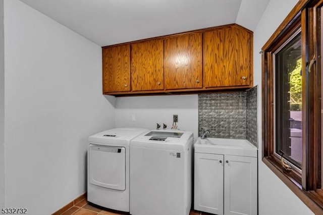 laundry area featuring light tile patterned flooring, cabinets, independent washer and dryer, and sink