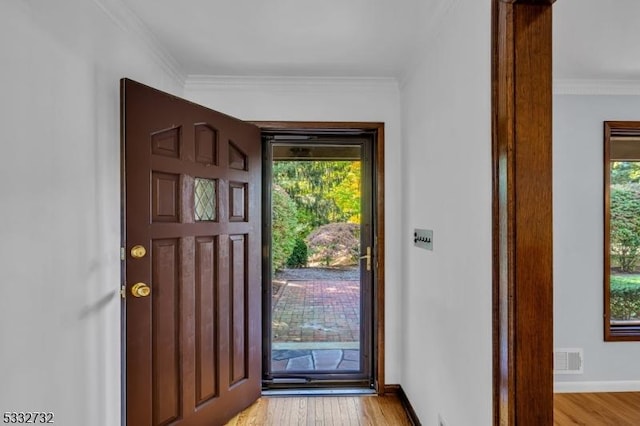 entryway with light wood-type flooring and ornamental molding