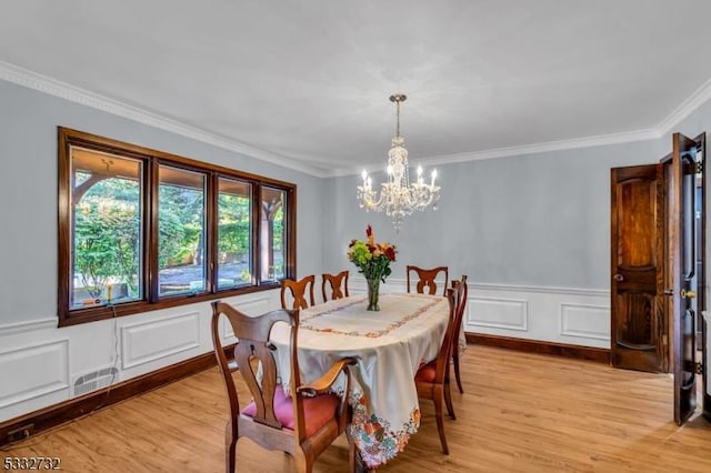 dining room featuring crown molding, a chandelier, and light wood-type flooring