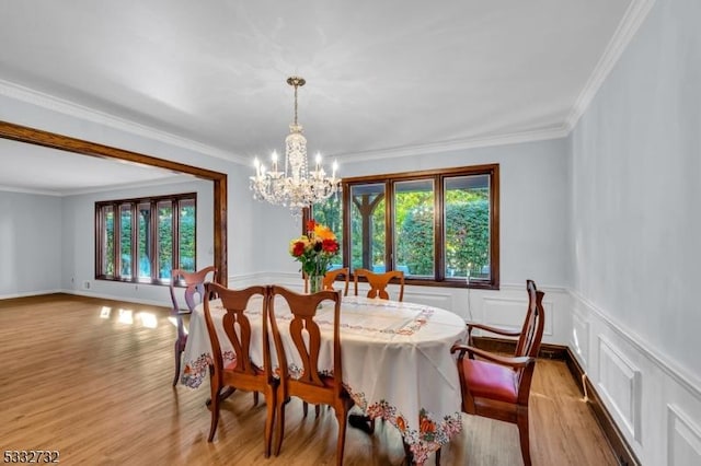 dining room featuring an inviting chandelier, light hardwood / wood-style floors, and ornamental molding