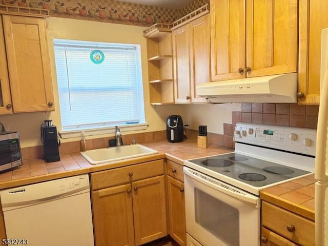 kitchen with tile counters, sink, and white appliances