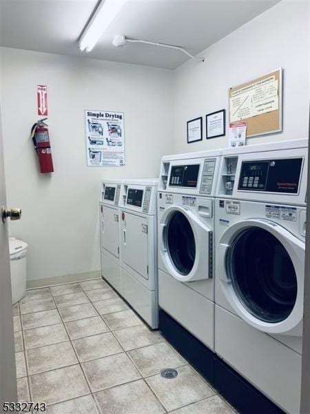 laundry area featuring light tile patterned flooring and washing machine and clothes dryer