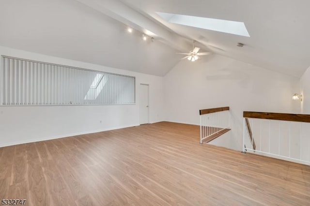 bonus room with light wood-type flooring, ceiling fan, and vaulted ceiling with skylight