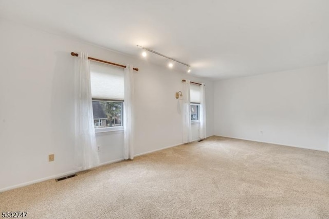 spare room with light carpet and track lighting