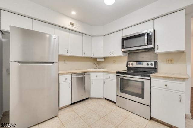 kitchen featuring sink, white cabinetry, and appliances with stainless steel finishes