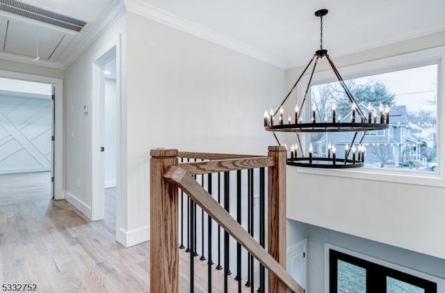 hallway featuring ornamental molding, light hardwood / wood-style floors, and a healthy amount of sunlight