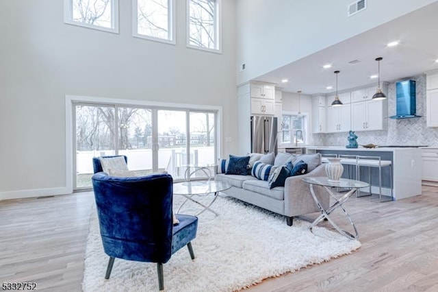 living room with a high ceiling and light hardwood / wood-style floors