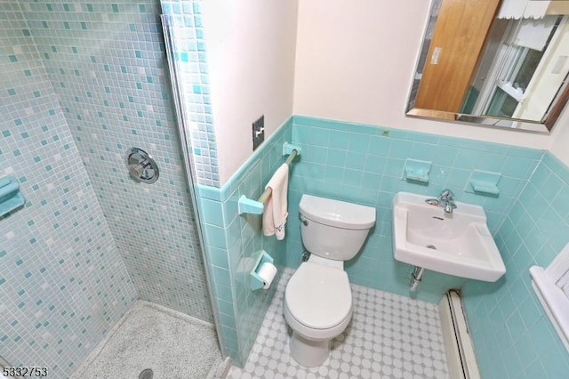 bathroom featuring tile walls, tiled shower, sink, and toilet