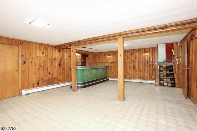 basement with wood walls and a baseboard radiator