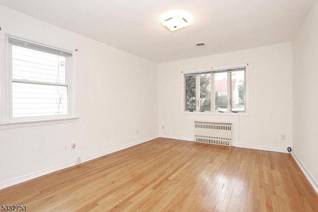 spare room featuring light wood-type flooring and radiator heating unit