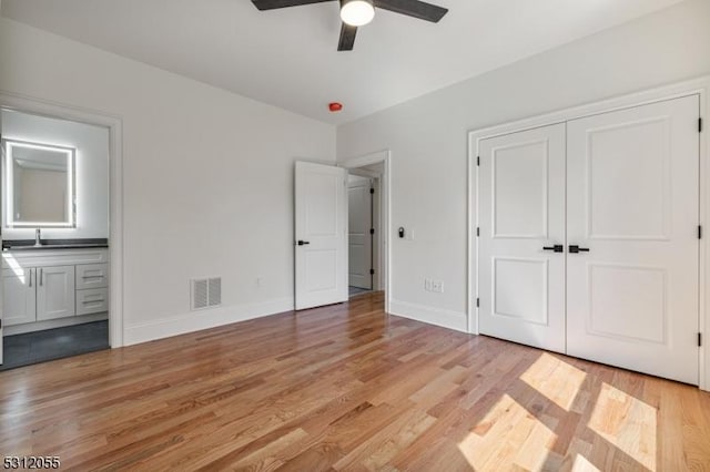 unfurnished bedroom with ceiling fan, a closet, and light wood-type flooring