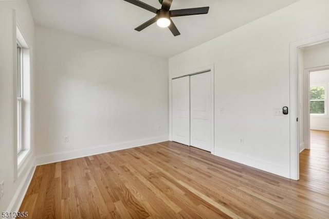 unfurnished bedroom with ceiling fan, a closet, and light wood-type flooring