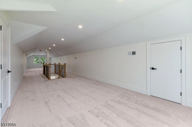 additional living space featuring light carpet and lofted ceiling