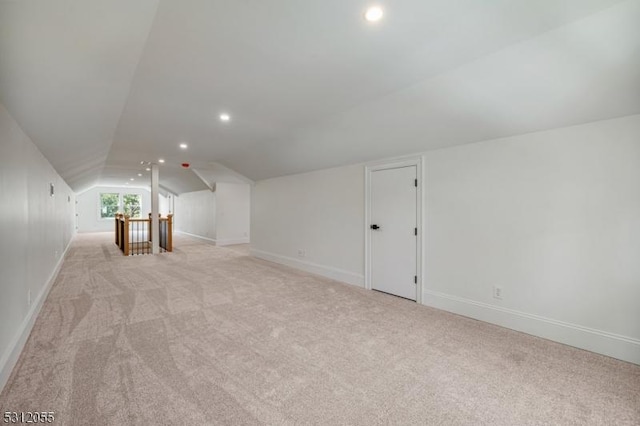 additional living space featuring light carpet and lofted ceiling