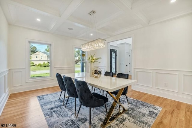 dining room with beamed ceiling, light hardwood / wood-style floors, ornamental molding, and coffered ceiling