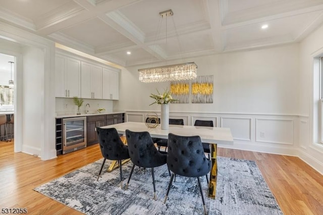 dining room with beam ceiling, light hardwood / wood-style floors, wine cooler, and coffered ceiling