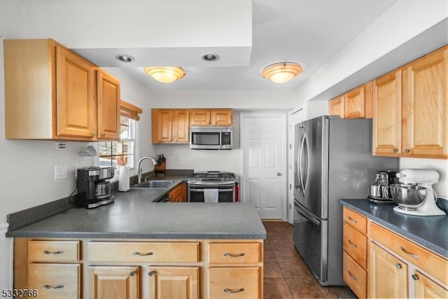 kitchen with stainless steel appliances, sink, light brown cabinets, and dark tile patterned flooring