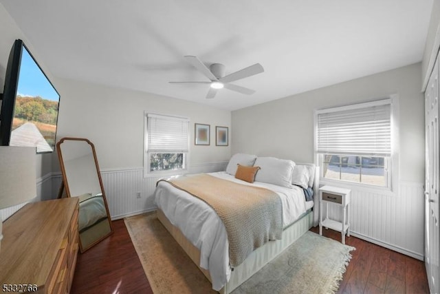 bedroom with multiple windows, dark hardwood / wood-style floors, and ceiling fan