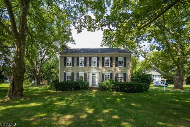 colonial house featuring a front lawn