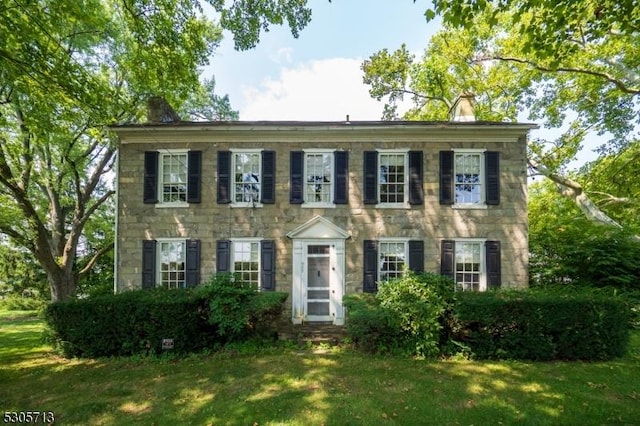 colonial-style house with a front lawn