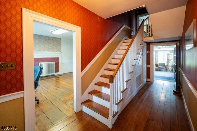 stairway featuring wood-type flooring and radiator heating unit