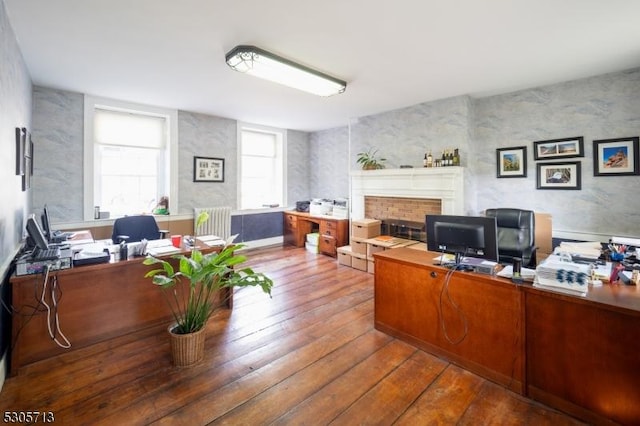 office space with a large fireplace and hardwood / wood-style floors