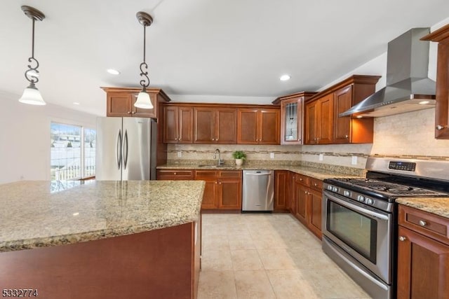 kitchen with appliances with stainless steel finishes, tasteful backsplash, hanging light fixtures, and wall chimney range hood