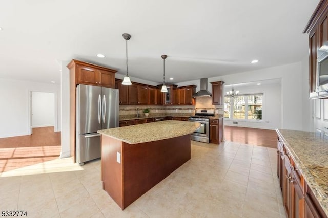 kitchen with stainless steel appliances, tasteful backsplash, decorative light fixtures, wall chimney exhaust hood, and a center island