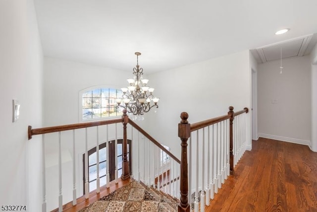 staircase featuring hardwood / wood-style floors and a notable chandelier