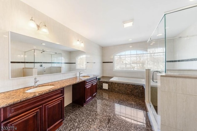 bathroom featuring vanity, tile walls, and independent shower and bath