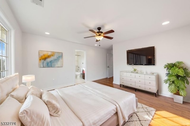 bedroom with ceiling fan, connected bathroom, and light hardwood / wood-style flooring